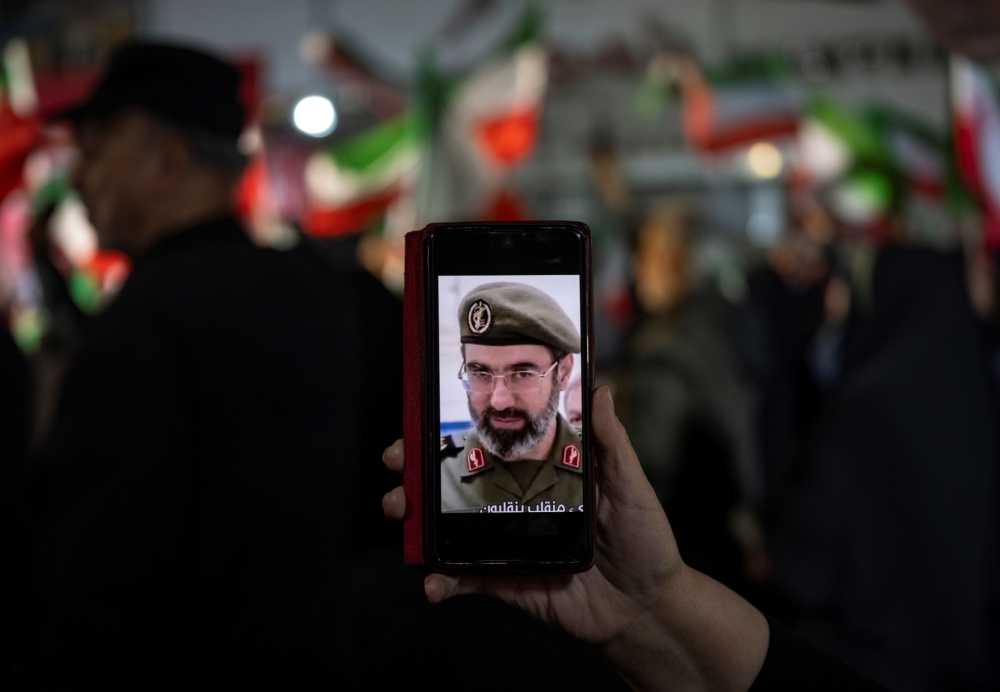 A woman displays an AI-generated image of Iran's new Supreme Leader, Ayatollah Mojtaba Khamenei, in an Islamic Revolutionary Guard Corps (IRGC) military uniform on her cellphone screen during a pro-government rally in downtown Tehran, Iran, on April 6, 2026.
