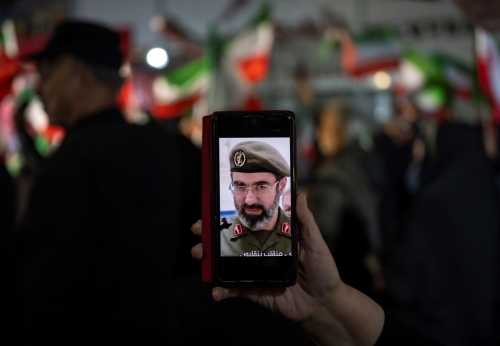 A woman displays an AI-generated image of Iran's new Supreme Leader, Ayatollah Mojtaba Khamenei, in an Islamic Revolutionary Guard Corps (IRGC) military uniform on her cellphone screen during a pro-government rally in downtown Tehran, Iran, on April 6, 2026.