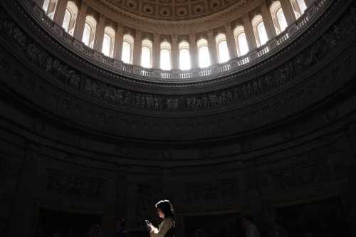 A woman looks at her cell phone while walking through the rotunda of the U.S. Capitol in Washington, D.C., on March 10, 2025