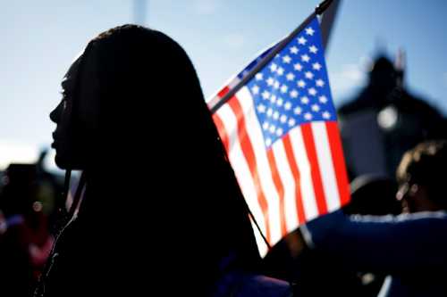 WASHINGTON, DC - OCTOBER 15: An activist holds a U.S. flag during a rally in front of the U.S. Supreme Court on Oct. 15, 2025. The Supreme Court heard oral arguments that day in Louisiana v. Callais, a major case concerning a congressional map that created a second majority-Black district in Louisiana.