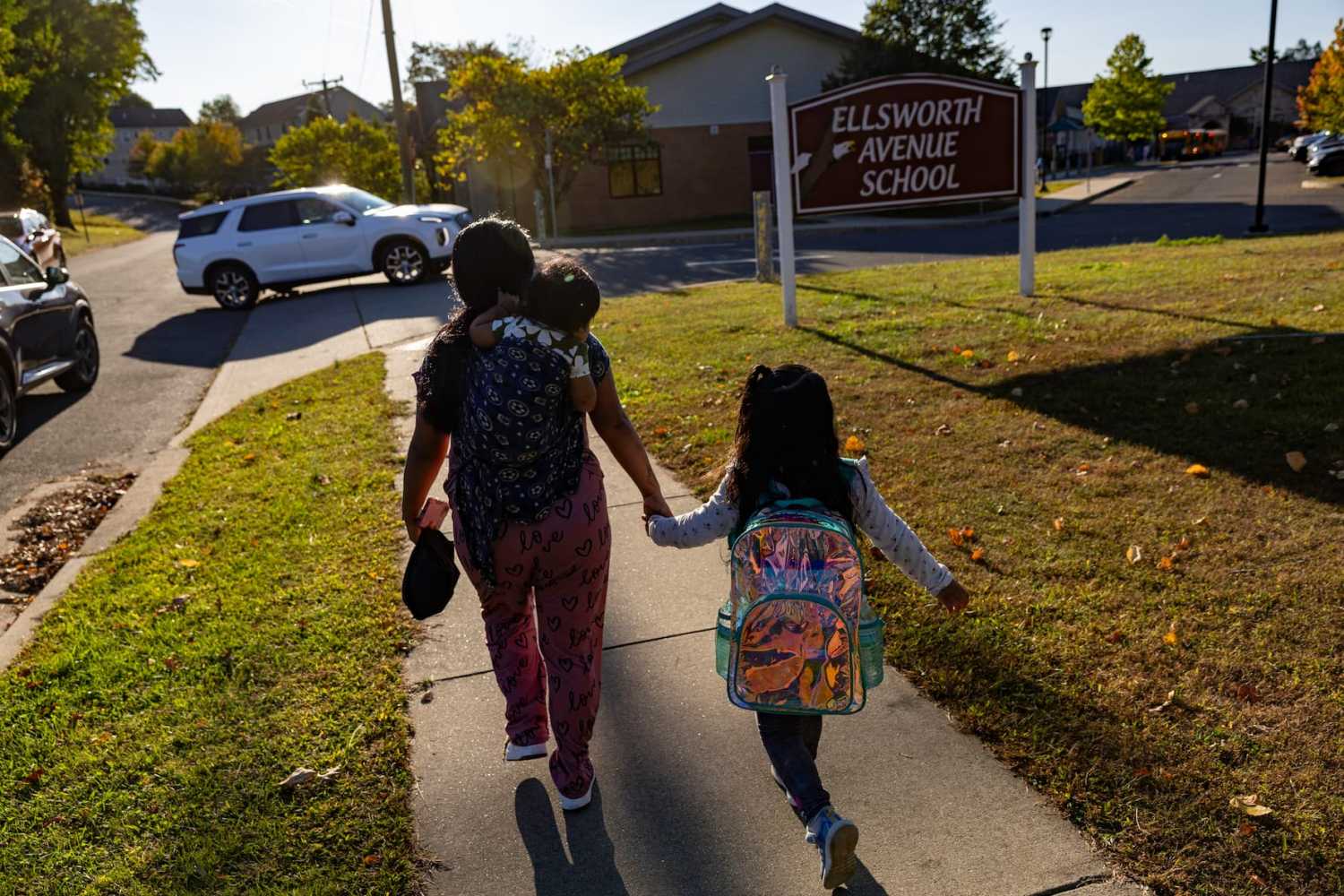 DANBURY, CONNECTICUT - OCTOBER 01: Undocumented Ecuadorian mother Andrea, 28, walks her daughter to school on October 1, 2025 in Danbury, Connecticut. Andrea and her cousin Jennyfer made the decision to "self deport" with their children after their husbands were detained by U.S. Immigration and Customs Enforcement (ICE) agents and later deported due to their undocumented status.