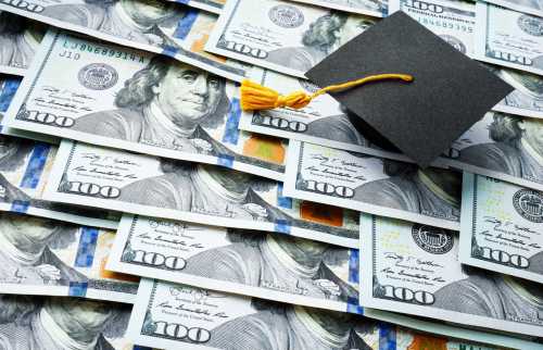 A graduation cap on top of stacks of USD