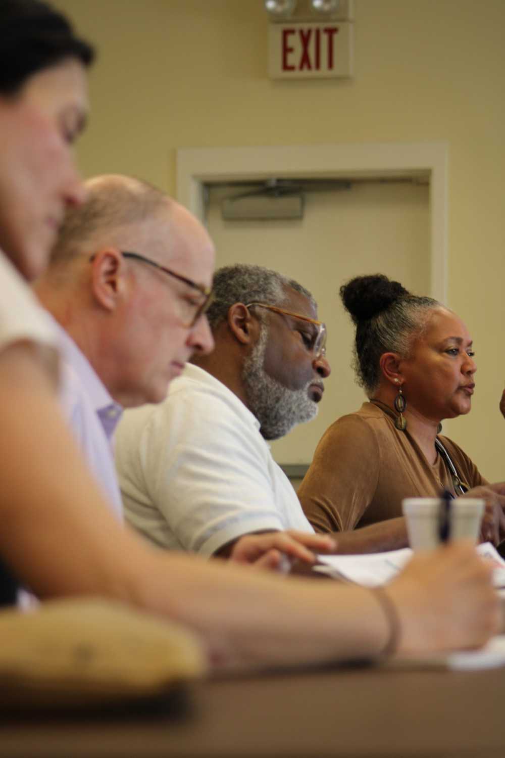 Commission Members Noa Meyer, Keith Humphreys, and Bill Bynum taking notes as W.K. Kellogg Foundation director Rhea Williams-Bishop speaks about federal funding navigation for small communities.