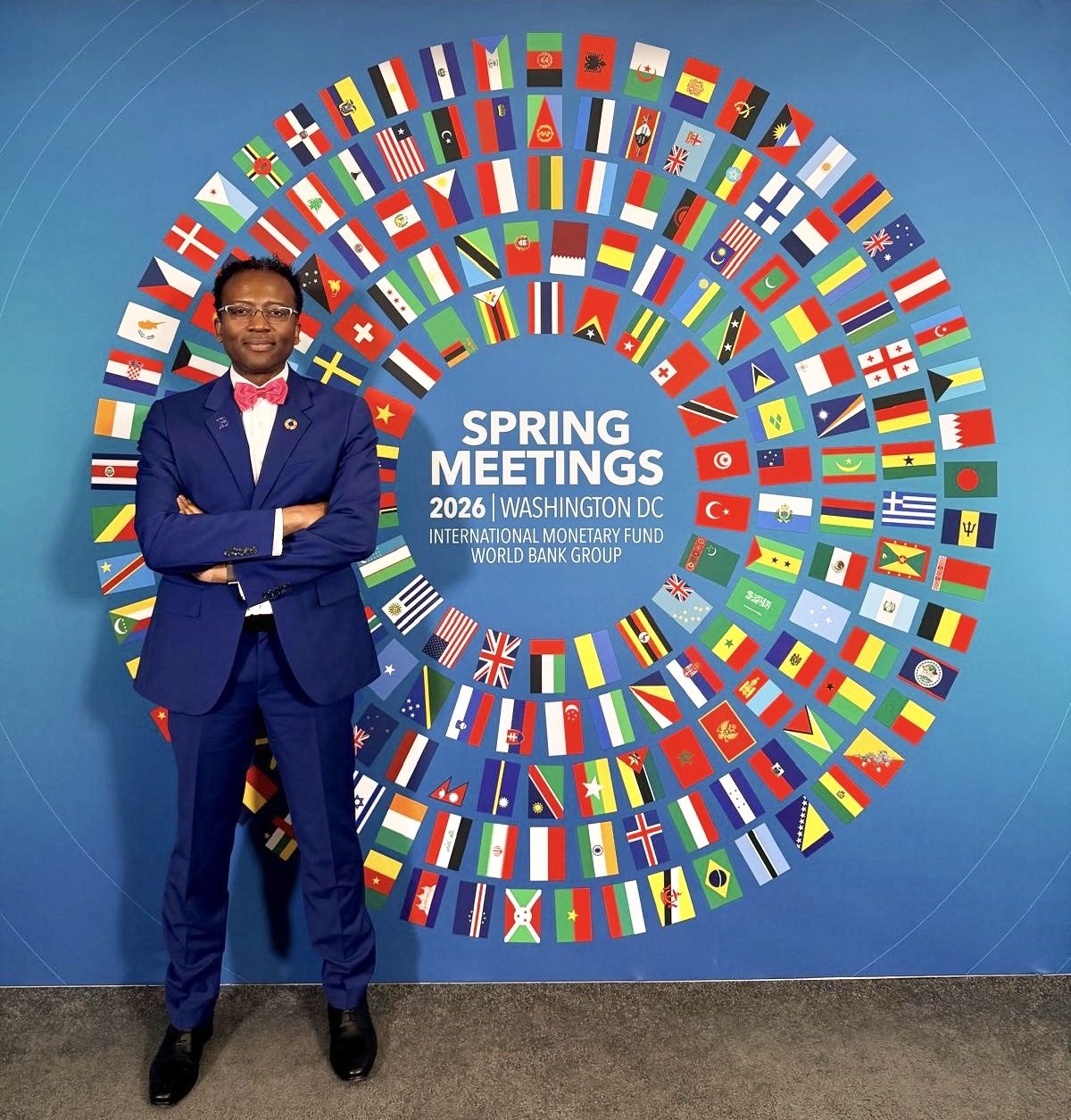 Brookings Senior Fellow Landry Signé standing in front of a sign for the 2026 Spring Meetings of the IMF and World Bank Group