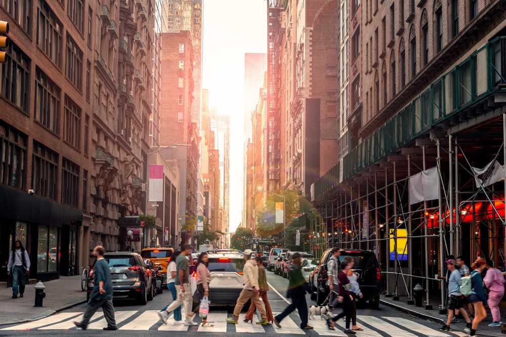 People crossing the street in Manhattan at sunset. New York City, USA