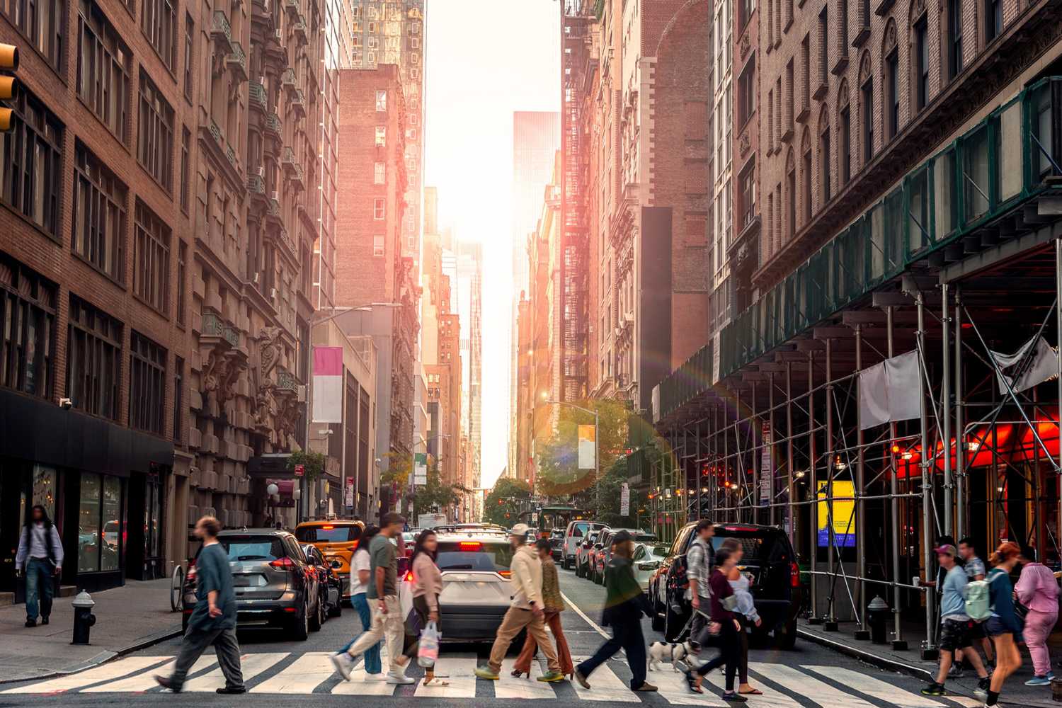 People crossing the street in Manhattan at sunset. New York City, USA