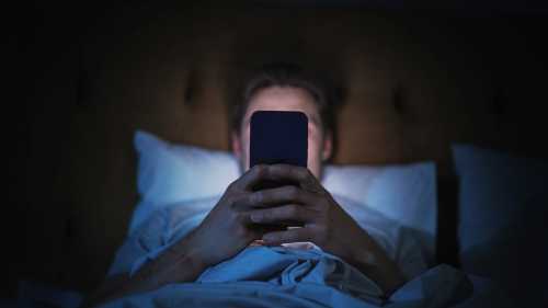 Person uses cellphone in bed