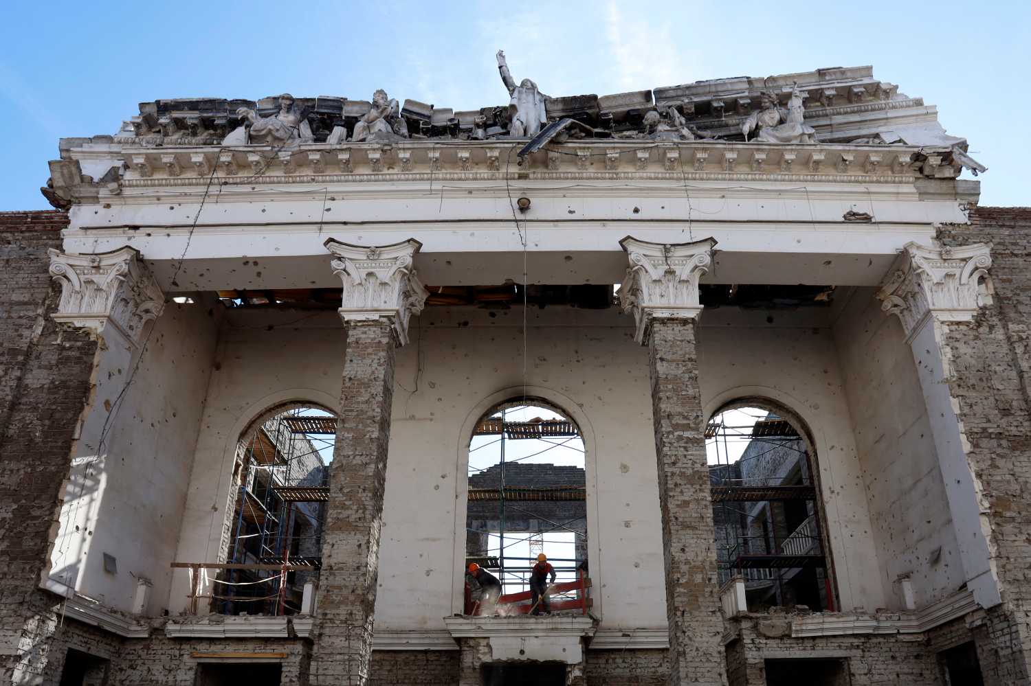 Construction workers rebuild the Mariupol Drama Theatre in Mariupol, Russian-controlled Ukraine, on April 4, 2024.