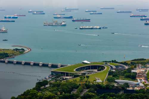 Ships waiting in the Strait outside the Marina Barrage in the waterfront area of the city of Singapore.