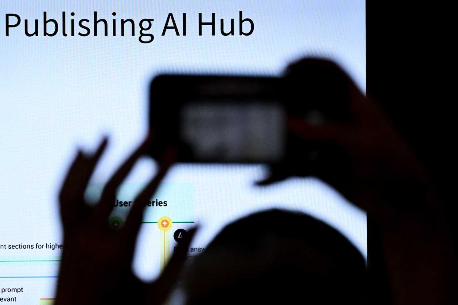 A person takes a picture of a screen during a presentation about AI (artificial intelligence) at the Frankfurt book fair on October 16, 2024, on the first day of the world's biggest book fair in Frankfurt am Main, western Germany. The Frankfurt Book Fair, in its 76th edition in the year 2024, runs from Wednesday, October 16, to Sunday, October 20, 2024.