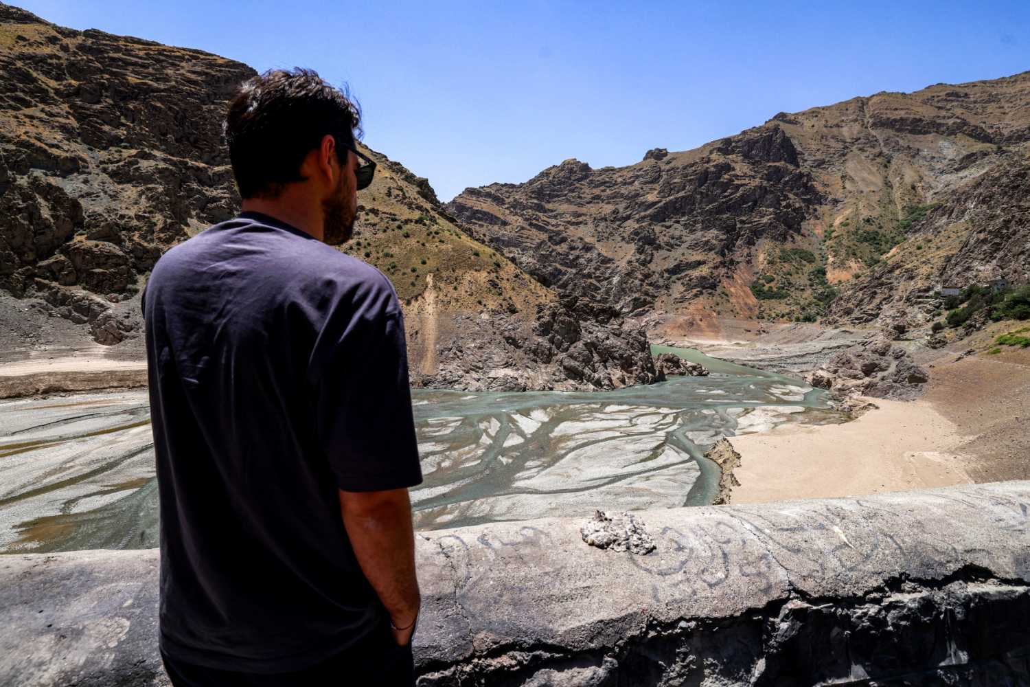 A man views the low water inlet of the river upstream of the Amir Kabir dam along the Karaj river in Iran's northern Alborz mountain range on June 1, 2025.