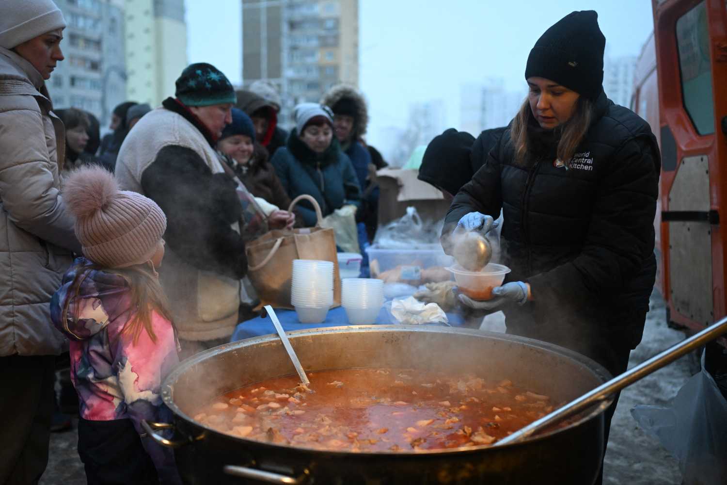 Volunteers of the US-based food charity World Central Kitchen distribute hot meal to local residents in a residential area of Kyiv that has been left without electricity and water due to recent Russian strikes battering the energy sector on January 22, 2026, amid the Russian invasion of Ukraine.