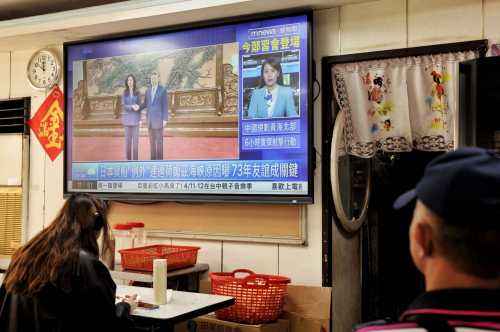 A television shows the meeting between Kuomintang (KMT) chairwoman Cheng Li-wun and Chinese President Xi Jinping in Beijing, at a restaurant in Taipei on April 10, 2026.