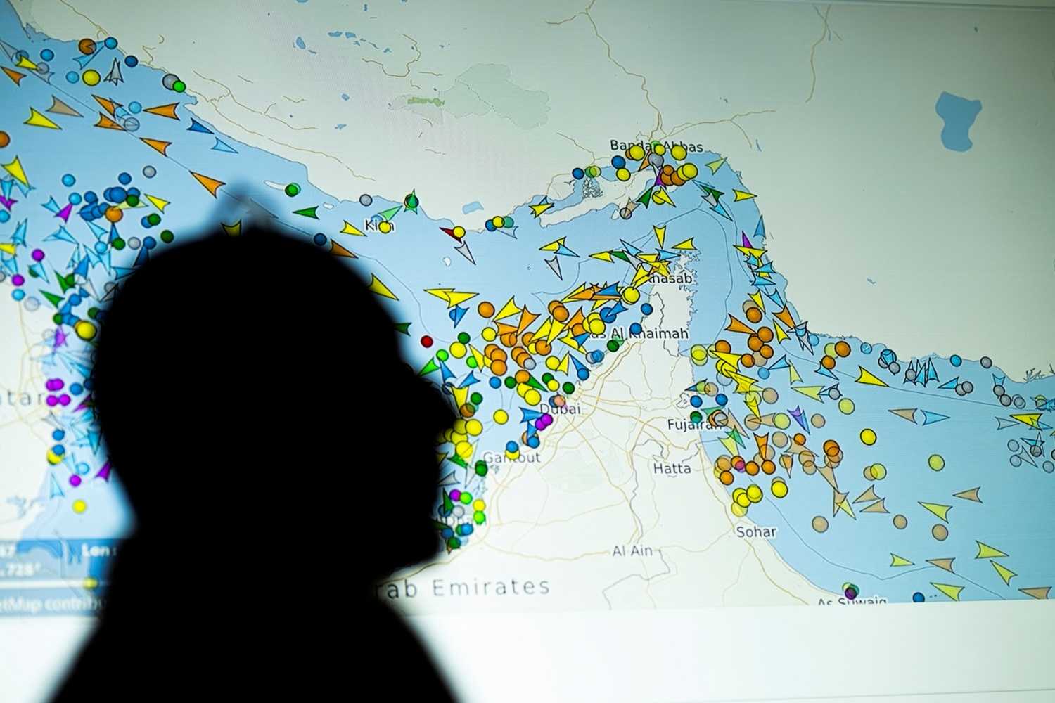 A photo illustration taken in Nicosia on May 4, 2026, shows a person in front of a large screen displaying vessel movements in the Strait of Hormuz on a ship-tracking website.
