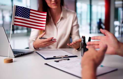 A two-person meeting with clipboards and a US flag.