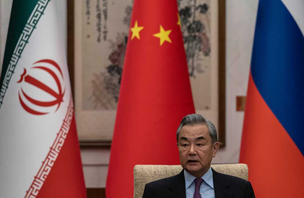 China's Foreign Minister Wang Yi, speaks during a meeting with Russian and Iranian officials about the Iranian nuclear issue at the Diaoyutai State Guesthouse in Beijing on March 14, 2025.