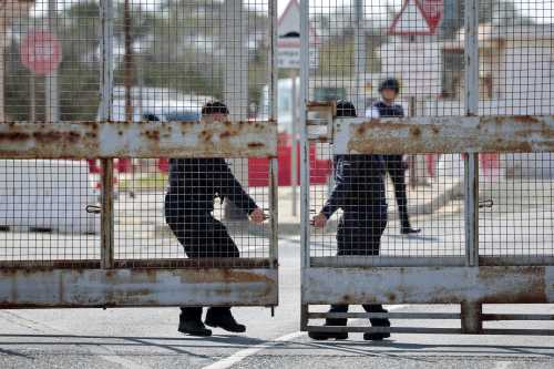 People operate the gate at RAF Akrotiri, a British sovereign base that was hit by a drone early on Monday, causing limited damage, after sirens sounded, in Cyprus, March 6, 2026.