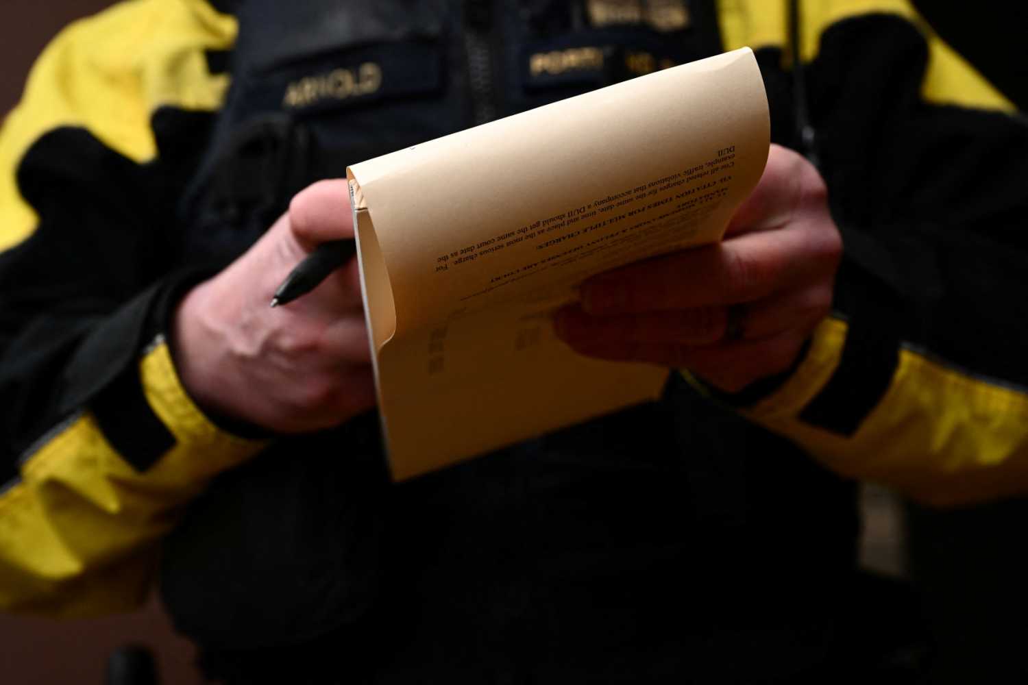 Portland Police officer Eli Arnold writes a ticket for smoking drugs in public during a patrol on a bicycle in downtown Portland, Oregon on January 25, 2024.
