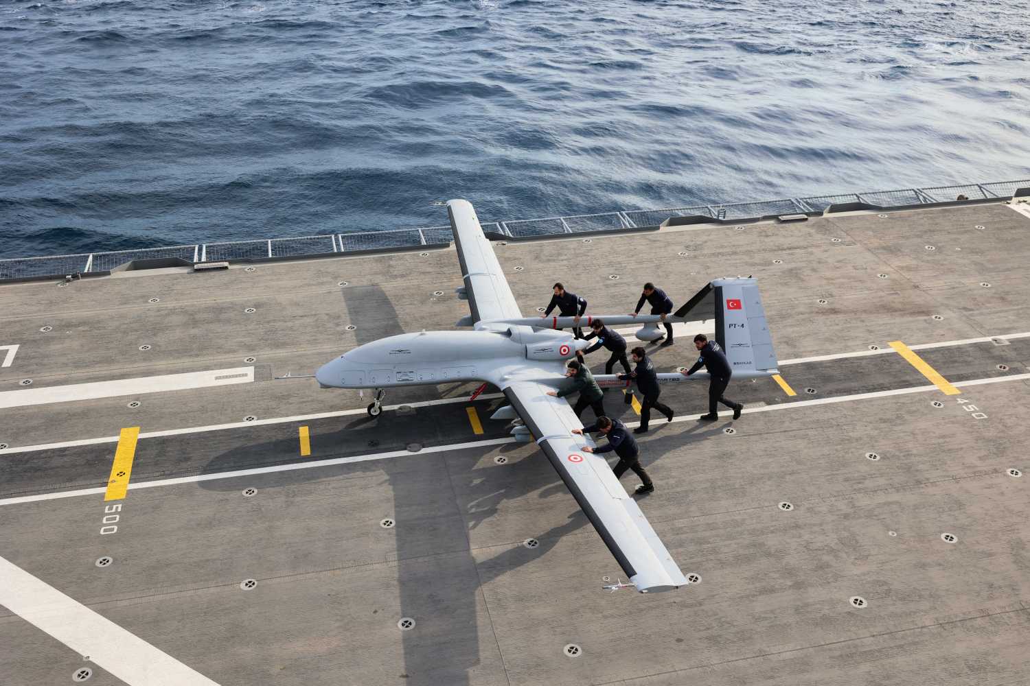 Military personnel push a Bayraktar TB3 drone, a Turkish carrier-based medium-altitude long-endurance (MALE) unmanned combat aerial vehicle (UCAV), during the live-fire phase of the "Blue Homeland-2026" (Mavi Vatan) tactical military exercises in the eastern Mediterranean Sea, in Antalya on April 9, 2026.