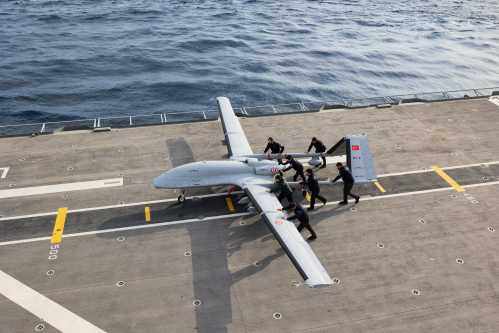 Military personnel push a Bayraktar TB3 drone, a Turkish carrier-based medium-altitude long-endurance (MALE) unmanned combat aerial vehicle (UCAV), during the live-fire phase of the "Blue Homeland-2026" (Mavi Vatan) tactical military exercises in the eastern Mediterranean Sea, in Antalya on April 9, 2026.