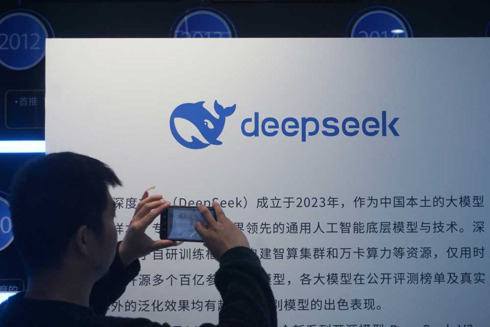 A man takes photos of a DeepSeek display at a shopping mall in Hangzhou, in China's eastern Zhejiang province