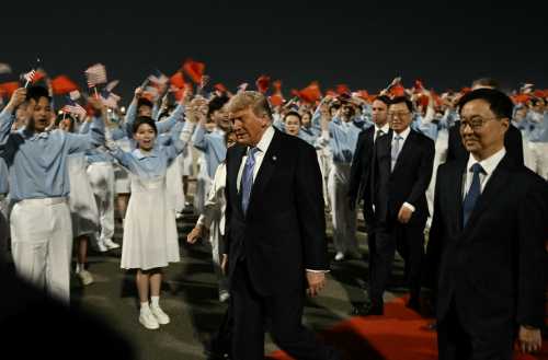 US President Donald Trump (C) is escorted by China's Vice President Han Zheng (R) upon his arrival at Beijing Capital Airport in Beijing on May 13, 2026.