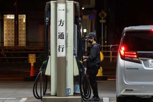 A driver refuels a vehicle at a gas station at night on May 10, 2026, in Tokyo, Japan.