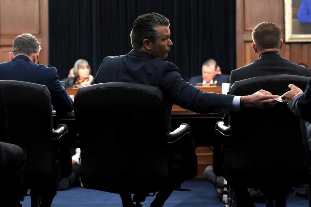 U.S. Secretary of War Pete Hegseth (C) hands an aide a note as he testifies during a House Committee on Appropriations, Subcommittee on Defense hearing in the Rayburn House Office Building on May 12, 2026 in Washington, DC.