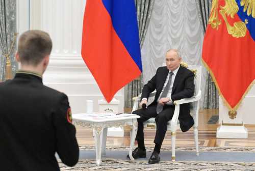 In this pool photograph distributed by the Russian state agency Sputnik, Russia's President Vladimir Putin meets with graduates of the "Time of Heroes" programme, which aims to integrate veterans of the Russian-Ukrainian conflict into high-ranking public positions, at the Kremlin in Moscow on May 22, 2026.