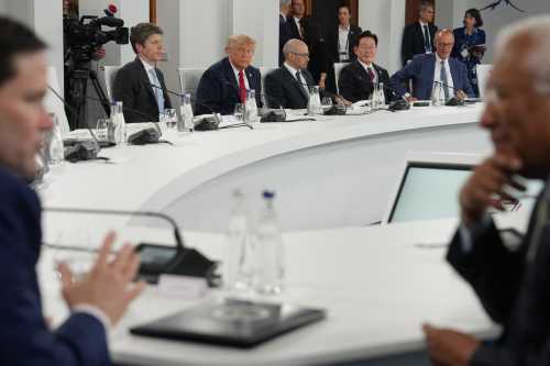 U.S. President Donald Trump reacts next to Open AI CEO Sam Altman and Google DeepMind CEO Demis Hassabis, South Korean President Lee Jae Myung, and Germany's Chancellor Friedrich Merz as U.S. Secretary of State Marco Rubio (L) and European Council President Antonio Costa (R) talk in the foreground during a working lunch meeting of G7 members, partner countries, and artificial intelligence business leaders as part of the G7 summit, in Evian, eastern France, on June 17, 2026.