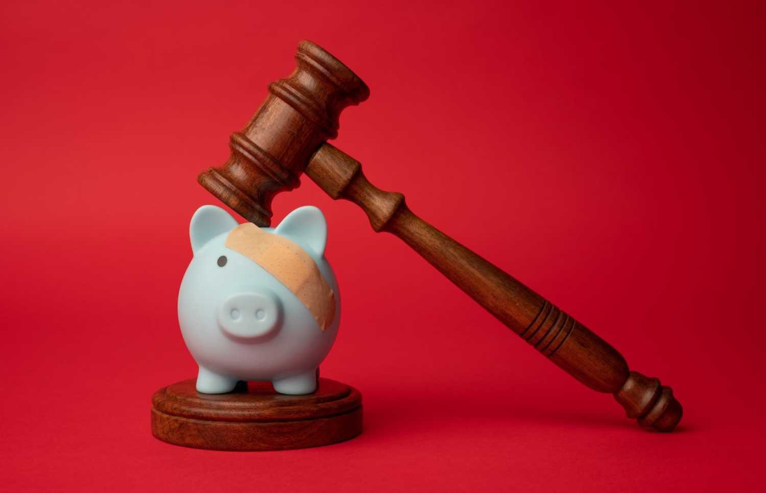 Broken piggy bank under wooden gavel