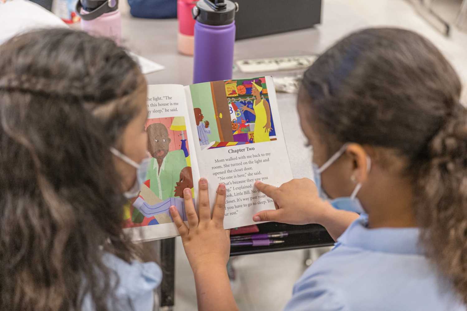 Two girls read a book together during a lesson at Carter Traditional Elementary School on January 24, 2022 in Louisville, Kentucky.