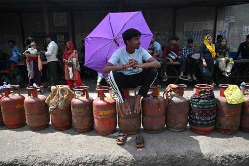 People wait to buy liquefied petroleum gas (LPG) cylinders at a gas agency office in Noida on April 2, 2026 amid ongoing oil and gas import disruptions caused by the Middle East war.