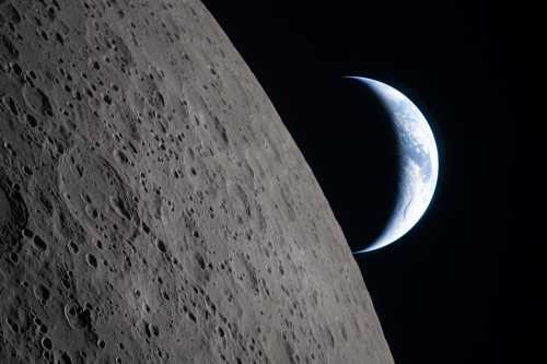 In this handout image provided by NASA, as the Artemis II crew came close to passing behind the Moon and experiencing a planned loss of signal, they captured this image of a crescent Earth setting on the Moon’s limb on April 6, 2026. In this photo, the dark portion of Earth is experiencing nighttime, while Australia and Oceania are in daylight. In the foreground, the Ohm crater is visible, with terraced edges and a flat floor interrupted by central peaks. Peaks such as these form in complex craters when the lunar surface is liquified on impact, and the liquefied surface splashes upward during the crater’s formation.