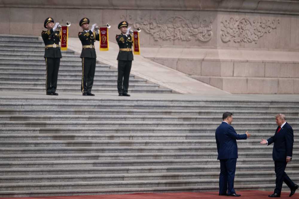 U.S. President Donald Trump (R) shakes hands with China's President Xi Jinping during a welcome ceremony at the Great Hall of the People in Beijing on May 14, 2026.
