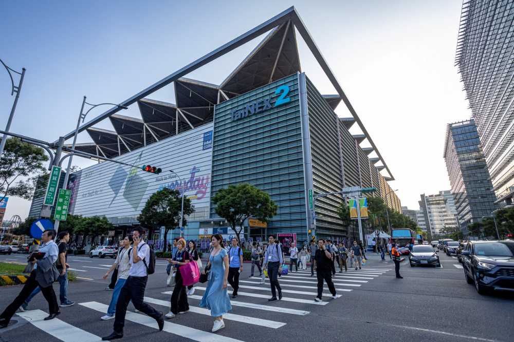 Pedestrians cross the street on a crosswalk in front of the Taipei Nangang Exhibition Center Hall 2 (TaiNEX 2) during COMPUTEX on June 02, 2026 in Taipei, Taiwan.