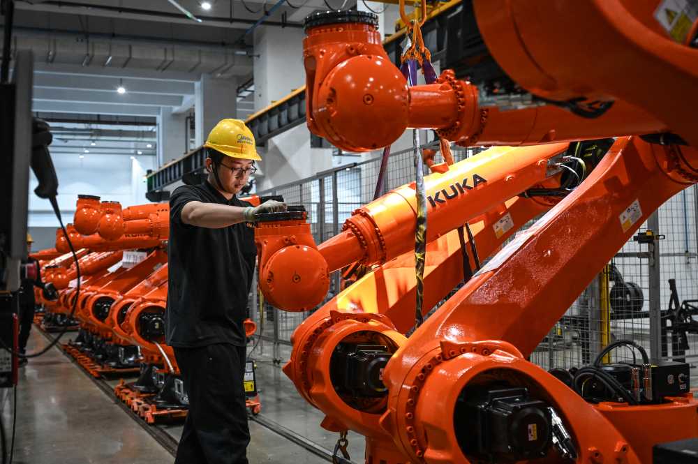 The photo taken on March 17, 2026 shows a worker working on an industrial robot assembly line at a KUKA factory in Foshan, in southern Guangdong province.