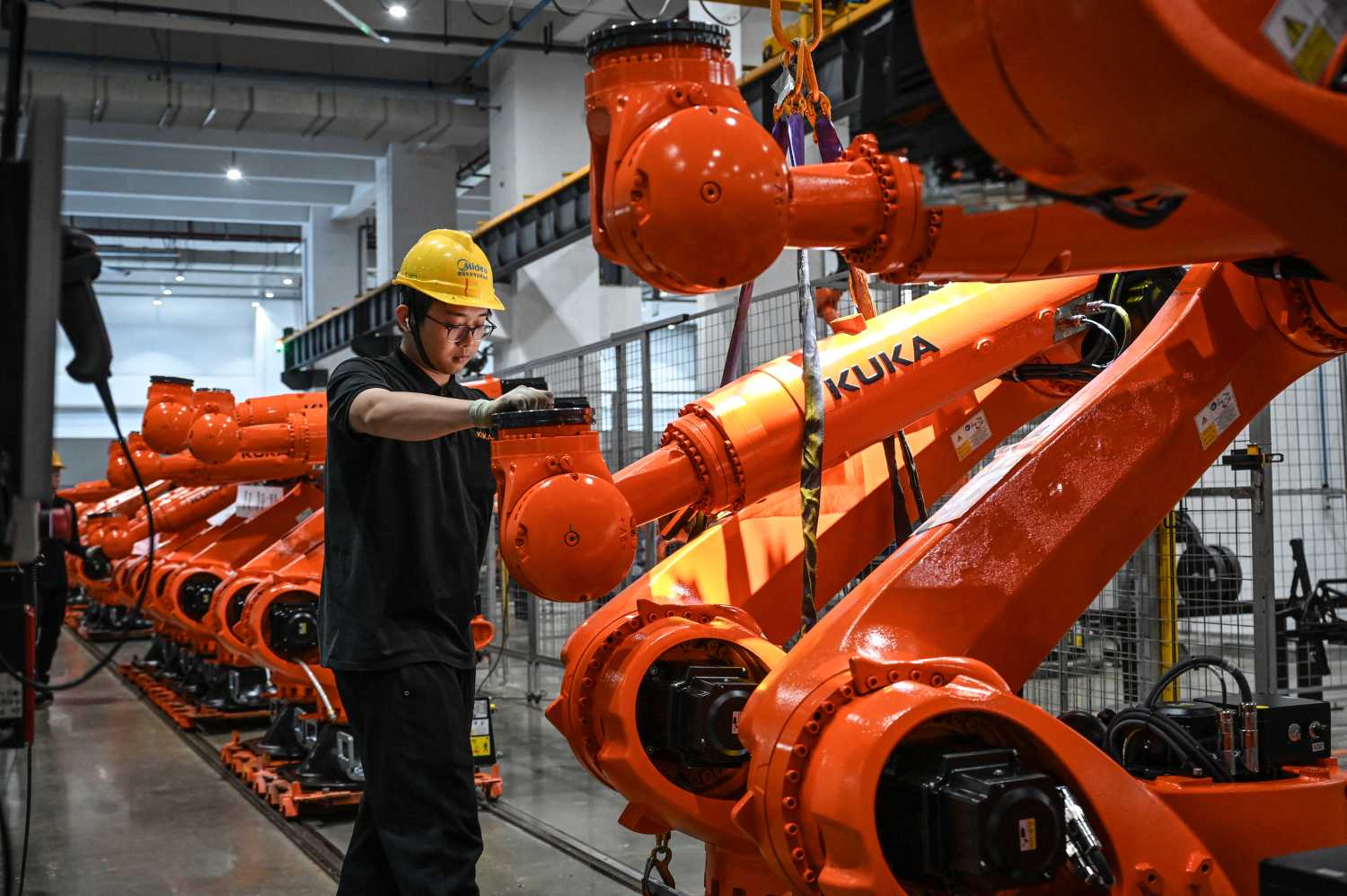 The photo taken on March 17, 2026 shows a worker working on an industrial robot assembly line at a KUKA factory in Foshan, in southern Guangdong province.