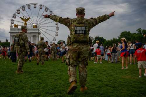 WASHINGTON, DC - JULY 04: National Guard and event security push people out of The Great American State Fair along the National Mall due to severe weather storms forecasted to arrive in the area on July 04, 2026 in Washington, DC.