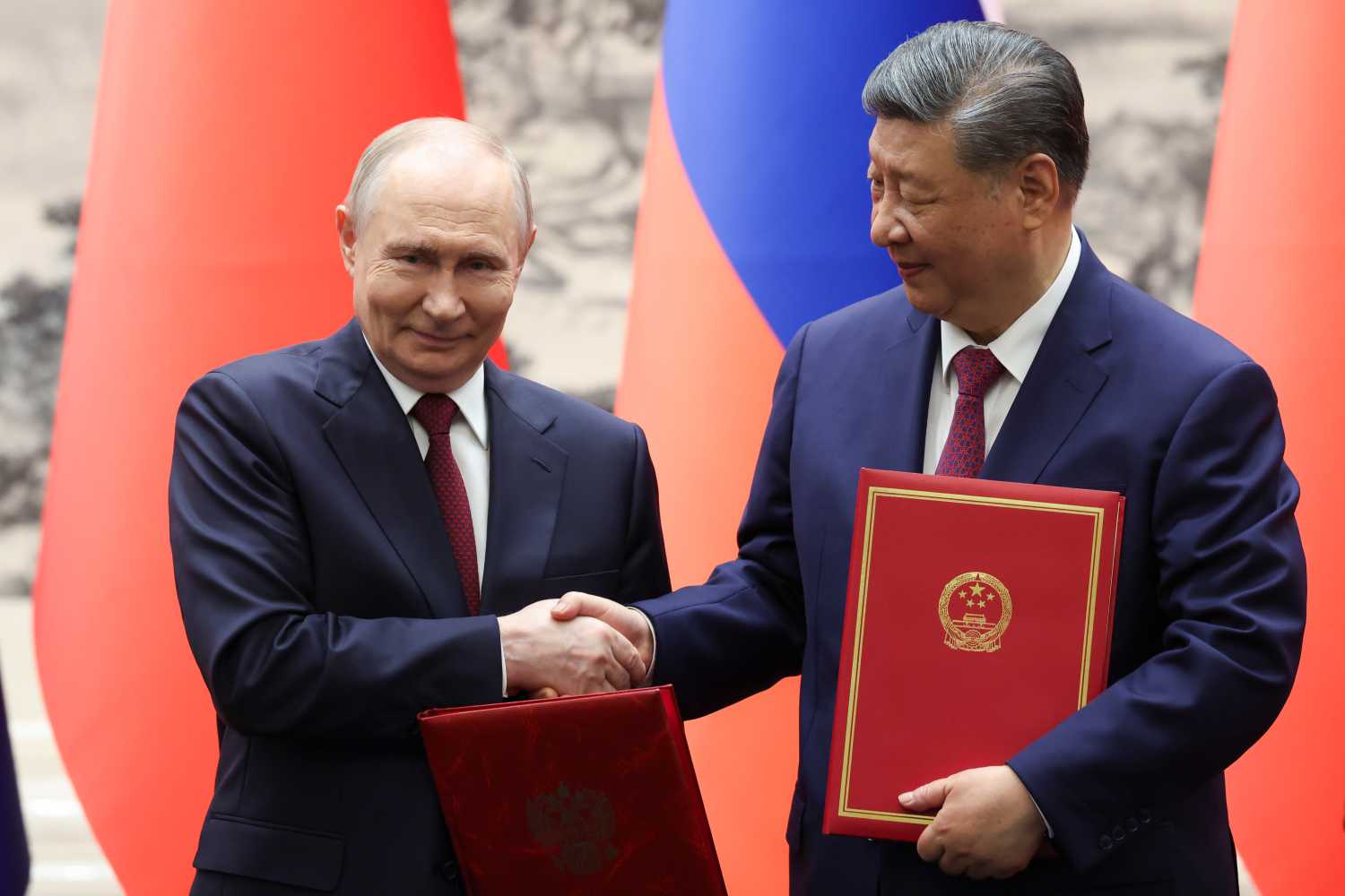 Russian President Vladimir Putin and Chinese President Xi Jinping shake hands during a signing ceremony at the Great Hall of the People on May 20, 2026 in Beijing, China