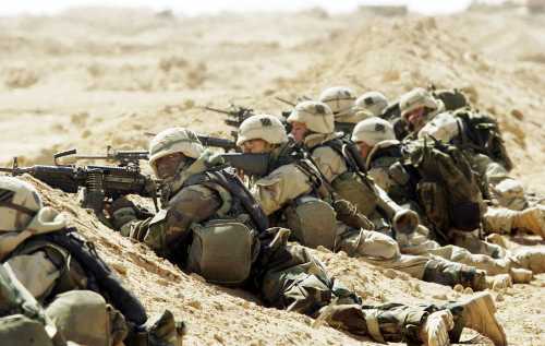 A U.S. Army 3rd Division 3-7 Infantry soldiers take cover after taking fire during a search and destroy mission March 27, 2003 near the town of An Najaf, Iraq.