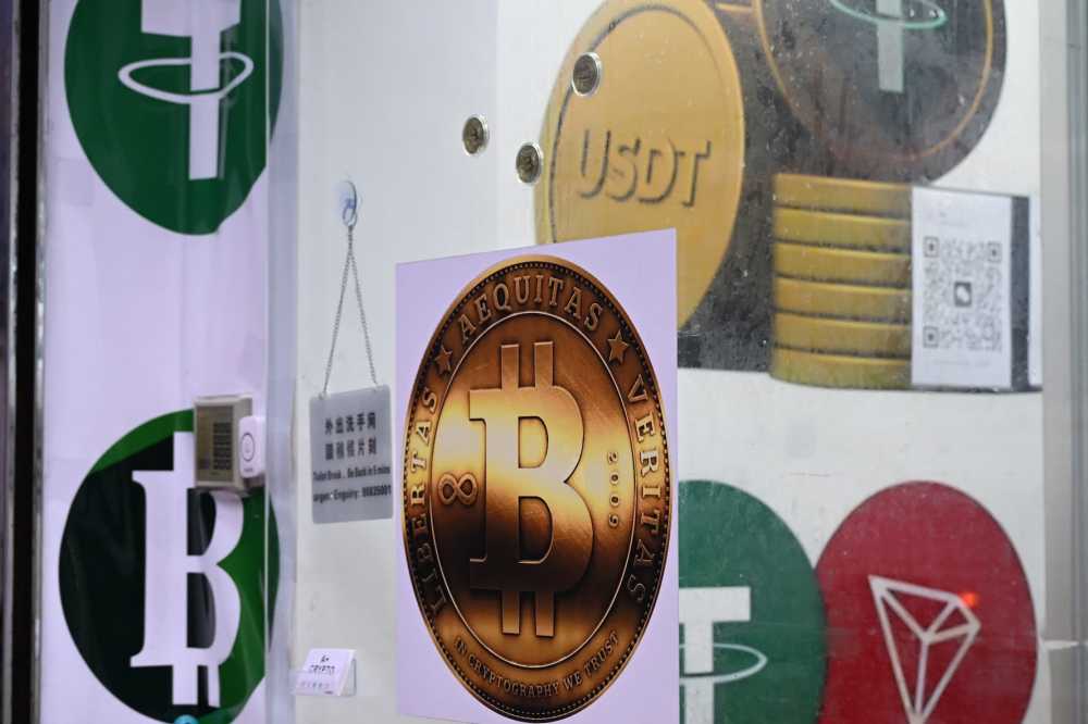 The symbols of bitcoin and the stablecoin Tether (USDT) are displayed at a cryptocurrency store in Hong Kong on July 29, 2025.