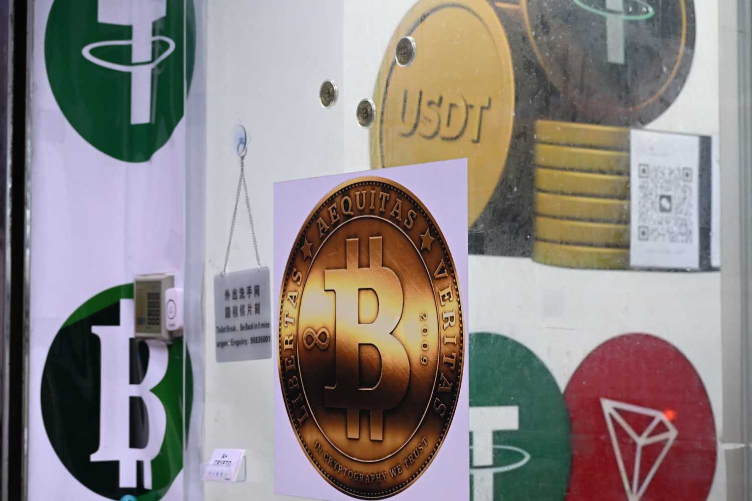 The symbols of bitcoin and the stablecoin Tether (USDT) are displayed at a cryptocurrency store in Hong Kong on July 29, 2025.