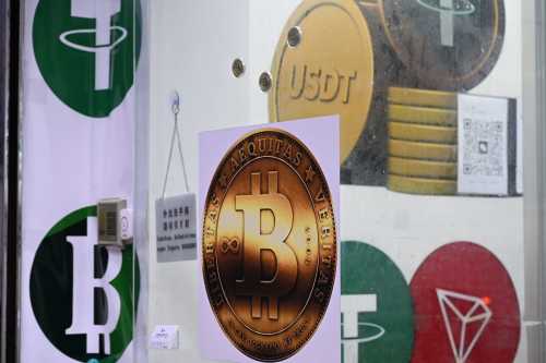 The symbols of bitcoin and the stablecoin Tether (USDT) are displayed at a cryptocurrency store in Hong Kong on July 29, 2025.