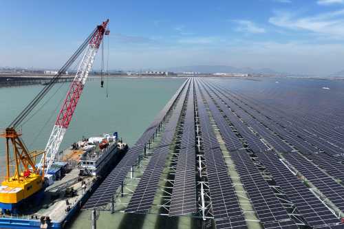 Workers install solar panels with a crane at the CNNC Tianwan tidal flat photovoltaic power plant in Lianyungang, in China's eastern Jiangsu province, on April 19, 2026.