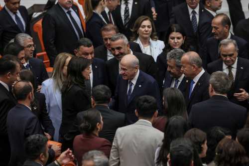 Turkish Nationalist Movement Party's (MHP) leader Devlet Bahceli (C) shake hands with Pervin Buldan (C-L), MP of Equality and Democracy (DEM) Party after voting a bill offering limited amnesty for Kurdish PKK militants at Grand National Assembly of Turkey in Ankara on August 10, 2026.