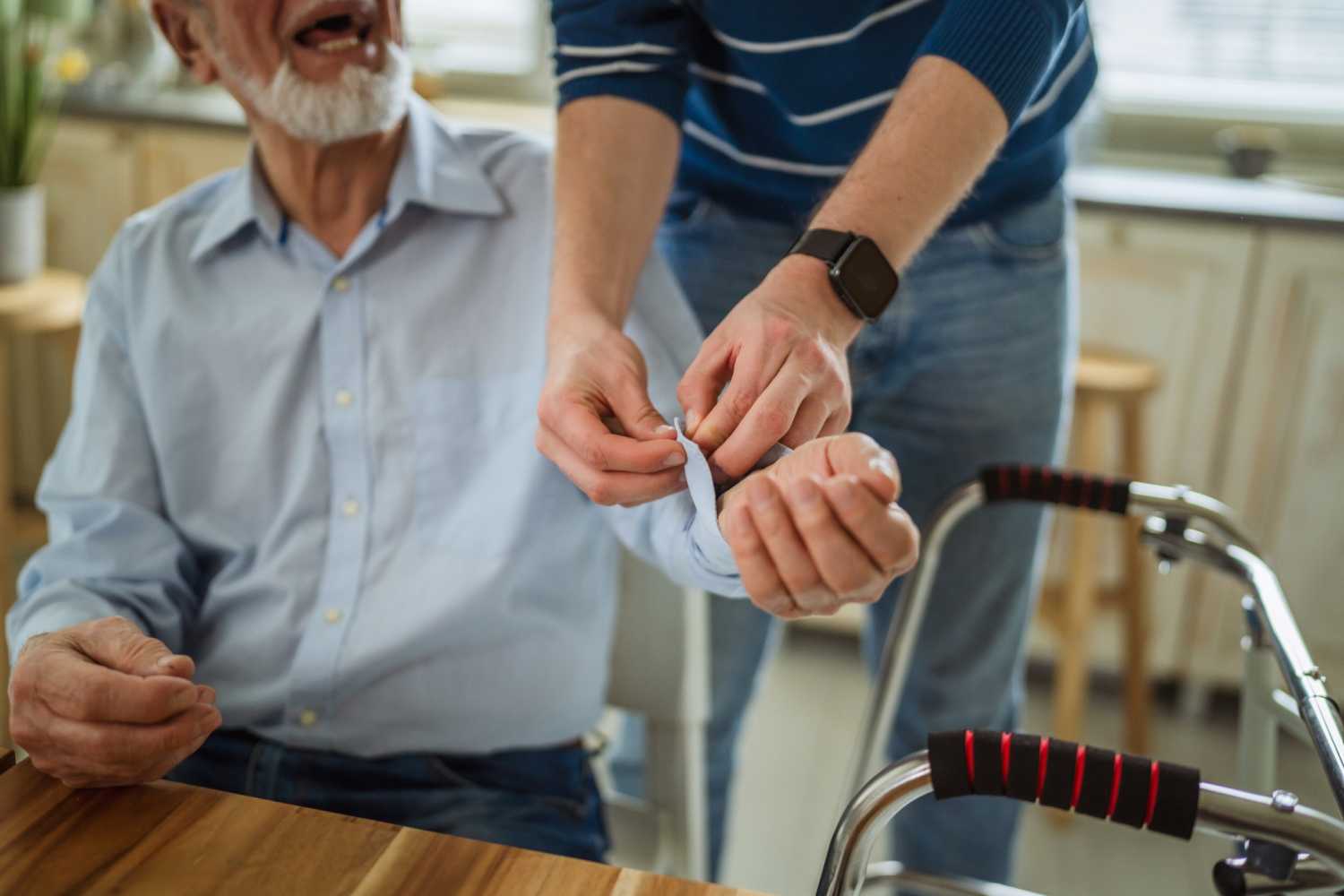 Careworker assisting older man at home with a blood pressure monitor