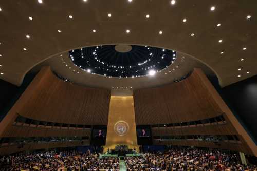 Wide view of the General Assembly Hall at the United Nations with seats filled while President Trump delivers remarks at the podium