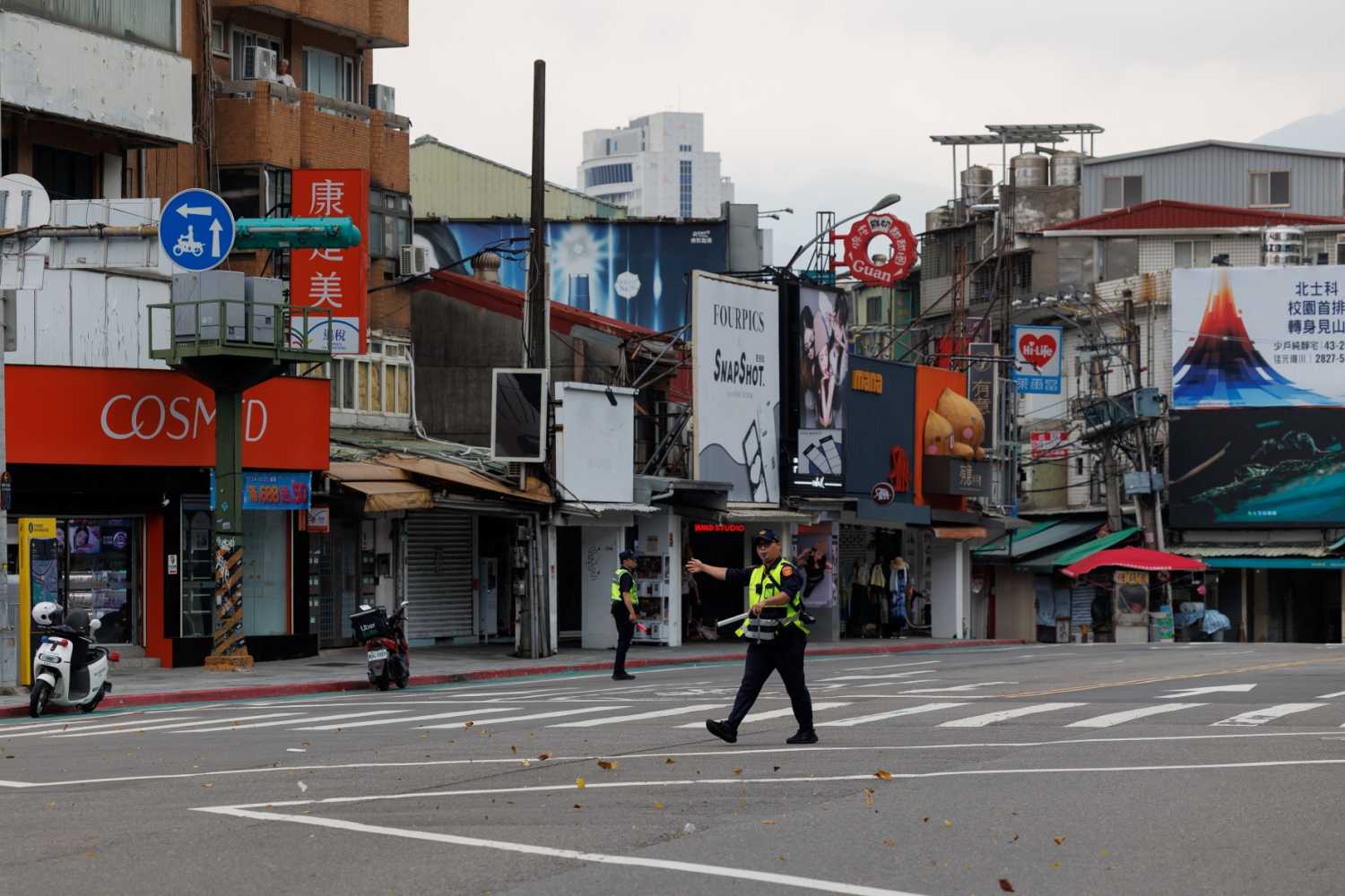 Policemen direct the public to a shelter during a simulation attack in Taipei on August 13, 2026. The drill was part of Taiwan's annual "Han Kuang" military exercise that aims to prepare the island of 23 million people for a potential Chinese invasion.