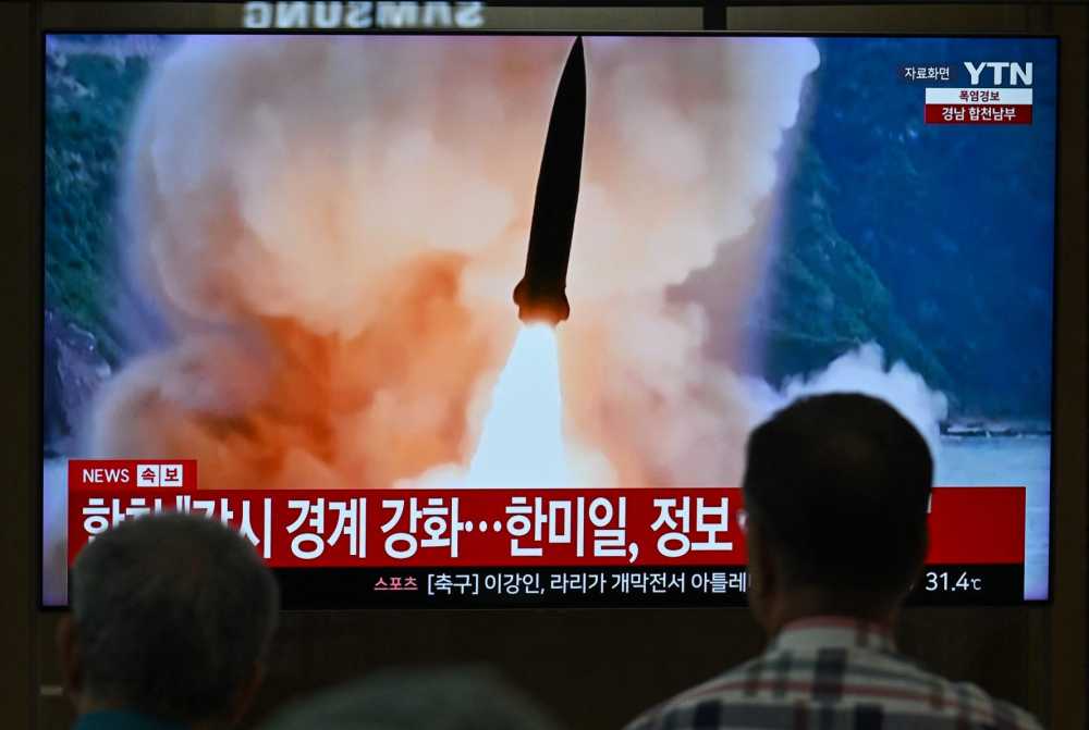 People watch a television screen showing a news broadcast with file footage of a North Korean missile test, at a train station in Seoul on August 20, 2026. North Korea fired around 10 short-range ballistic missiles, South Korea's military said on August 20, hours after US President Donald Trump said he would meet Pyongyang's leader Kim Jong Un later this year.